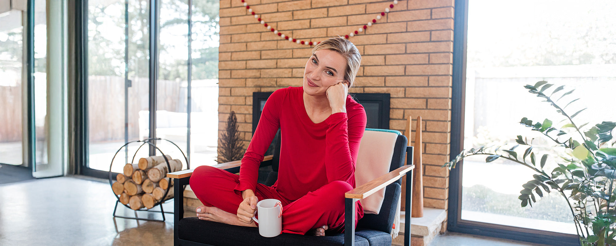 Woman in holiday red pajama set sitting in chair