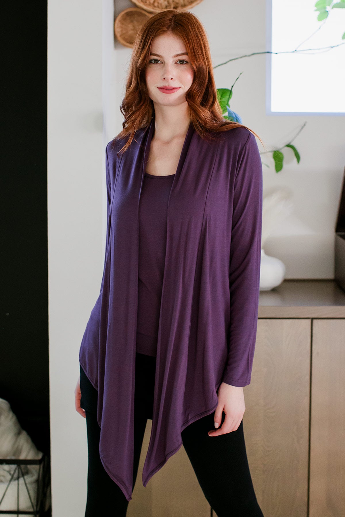 A woman standing and smiling with her hips tilted to the side, wearing Yala Sophie Bamboo Cardigan Wrap in Aster
