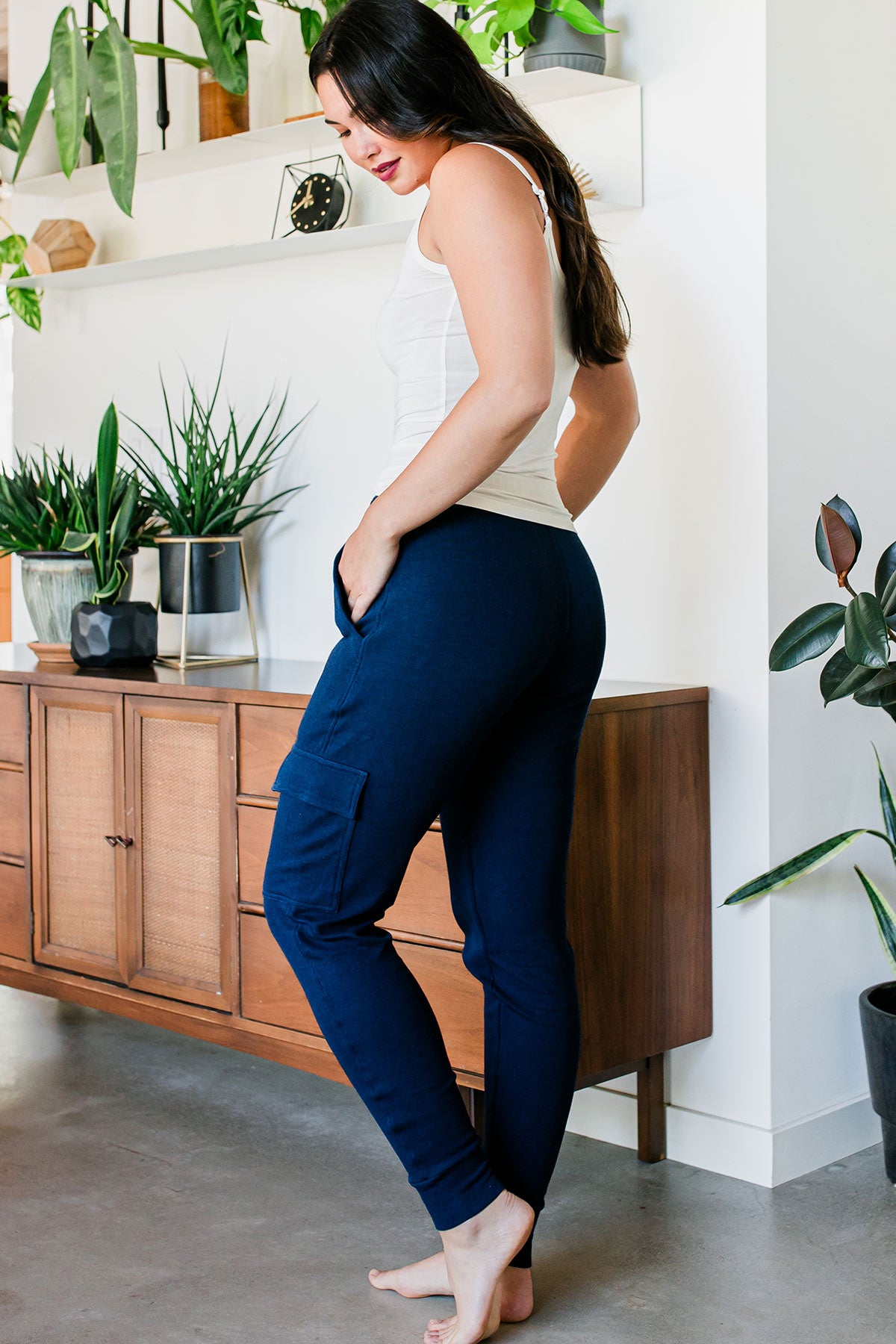 A woman standing facing to the side and away from the camera,her hands in her pockets, wearing Yala Fay Bamboo & Organic Cotton Cargo Joggers in Navy