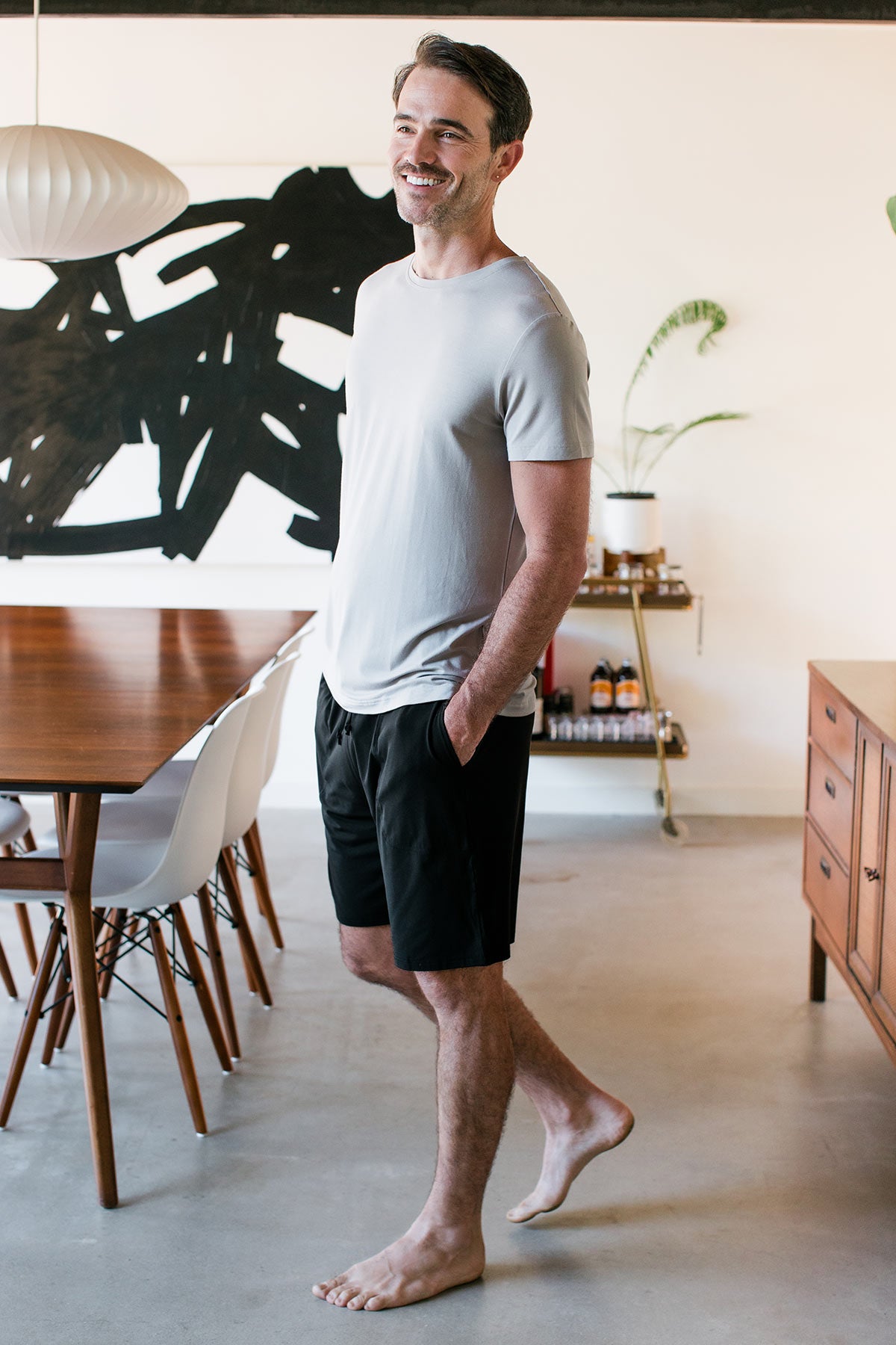 A man walking forward an looking to the side, wearing Yala Men's Mateo ButterSoft Bamboo Lounge Shorts in Black
