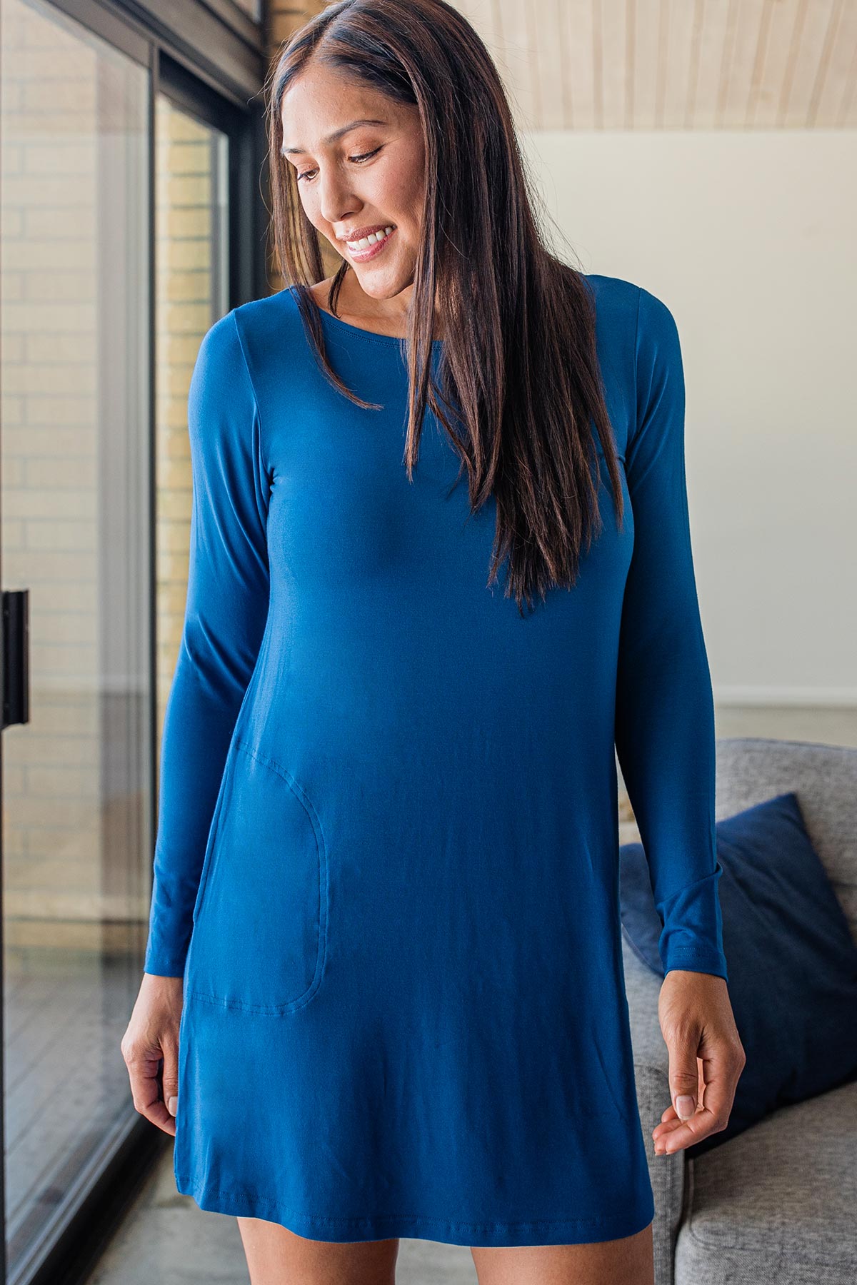 A woman standing and looking downwards and to the side, wearing Yala Mia A-Line Bamboo Dress in Lapis