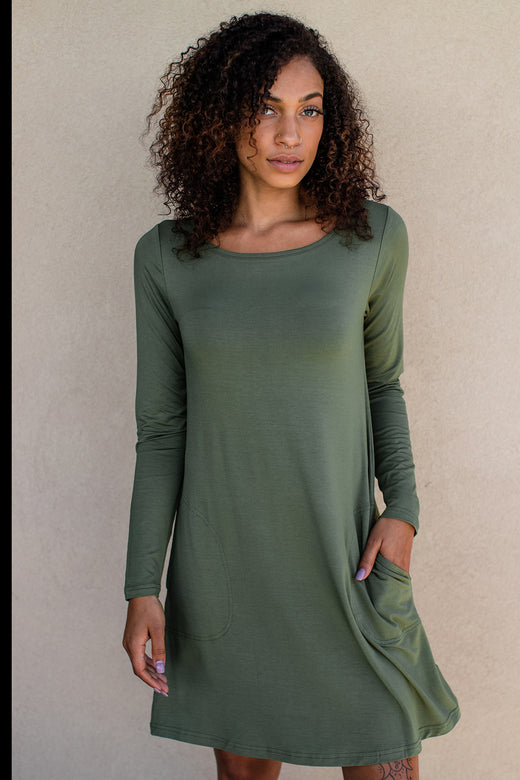 A woman standing with one hand in her pocket, wearing Yala Mia A-Line Bamboo Dress in Moss