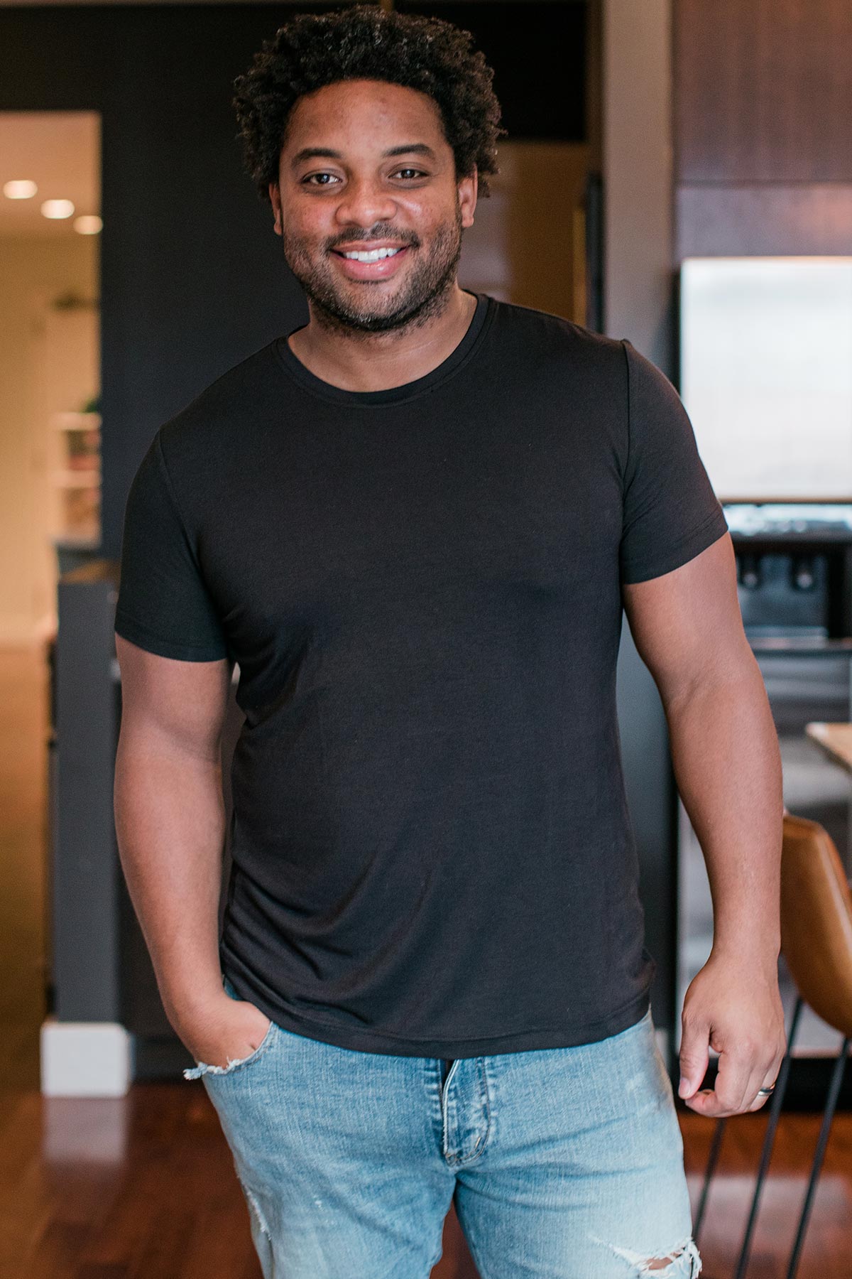 A man standing and smiling with one hand in his pocket, wearing Yala Nathan Men's Short Sleeve Bamboo Crew Tee Shirt in Black