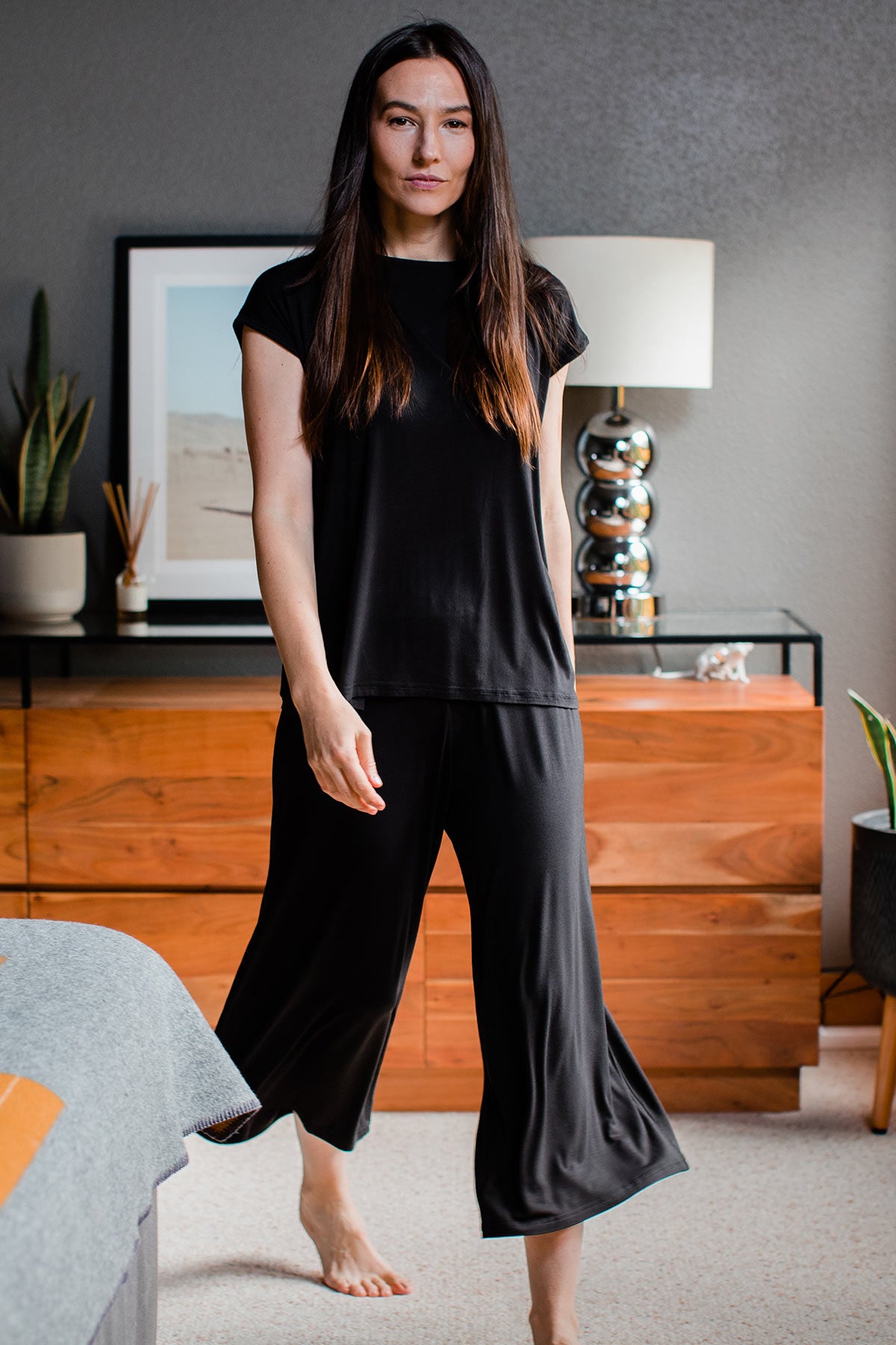 A woman walking forward, wearing Yala Opal Swing Lounge Bamboo Pajama Set in Black