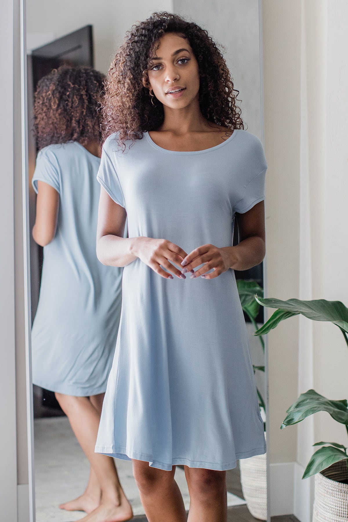 A woman standing with both hands held in front of her waist, wearing Yala Penelope Cap Sleeve Oversized Bamboo Nightshirt