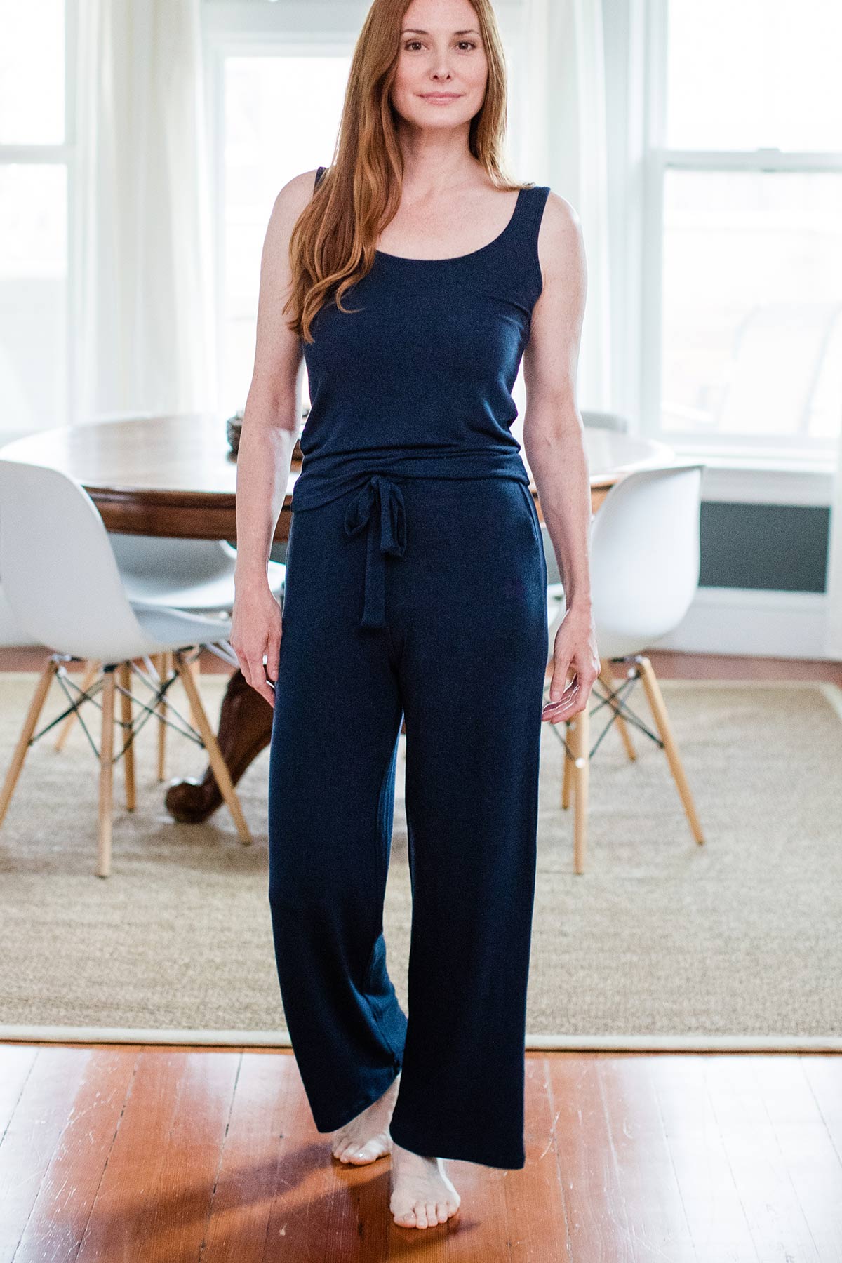 A woman standing with one foot forward, wearing Yala Peyton Bamboo Sweater Drawstring Lounge Pants in Navy