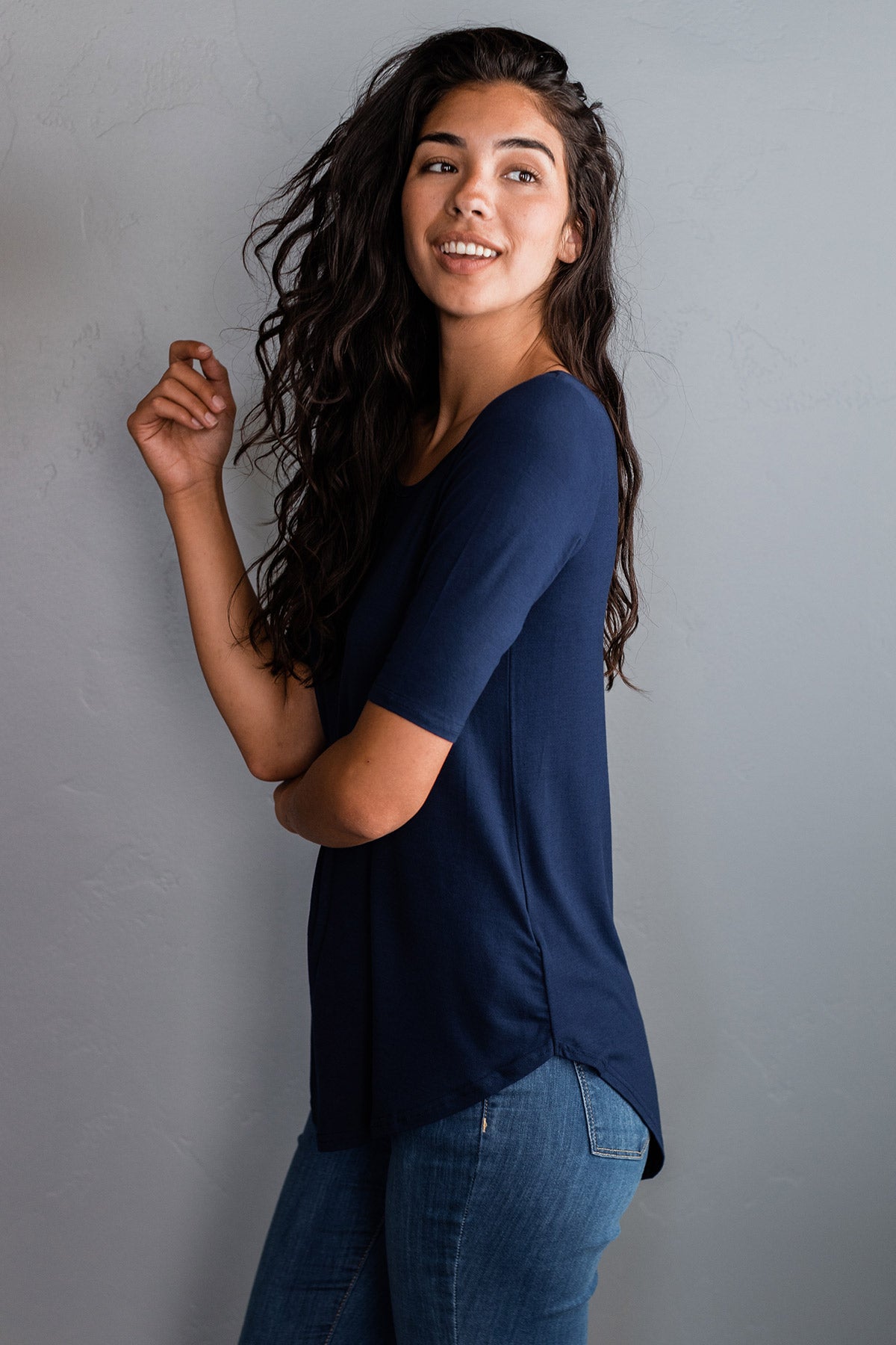 Woman looking over her shoulder, wearing Yala Sandy Bamboo Scoop Neck Short Sleeve Top in Navy