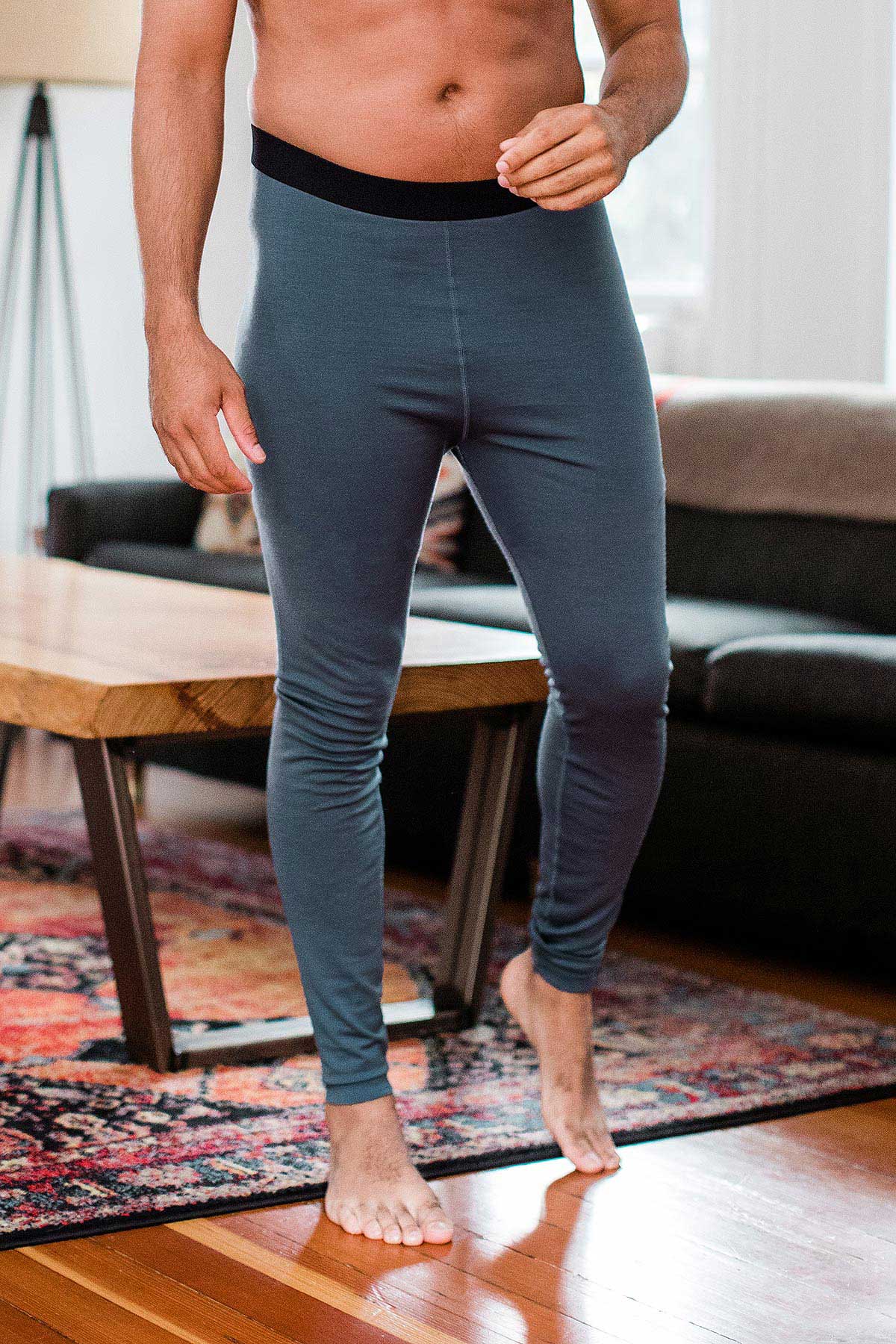 Close shot of a man's waist and legs, wearing Yala Superfine Merino Wool Leggings in Storm Grey