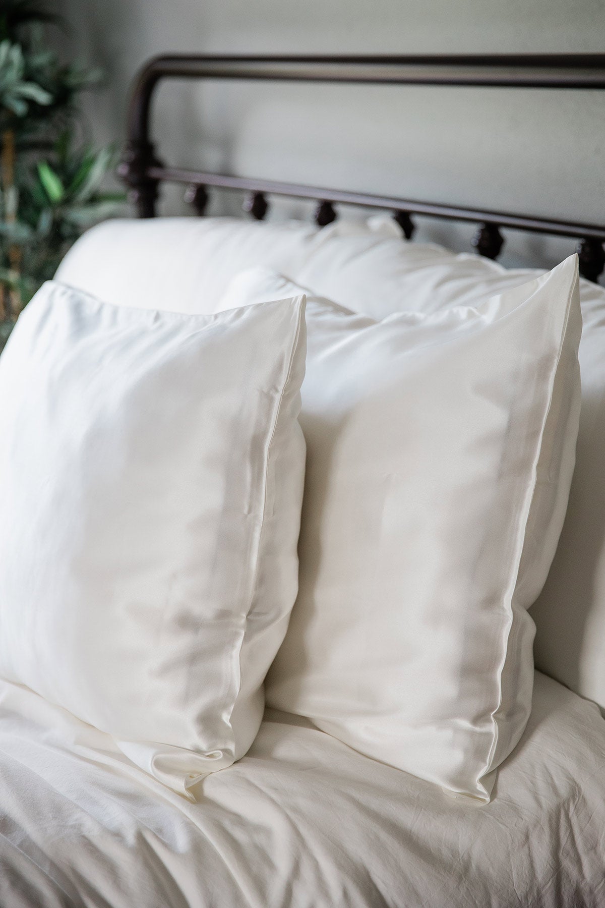 A pair of pillows enshrouded in Yala Charmeuse Pillowcase Set in Natural White