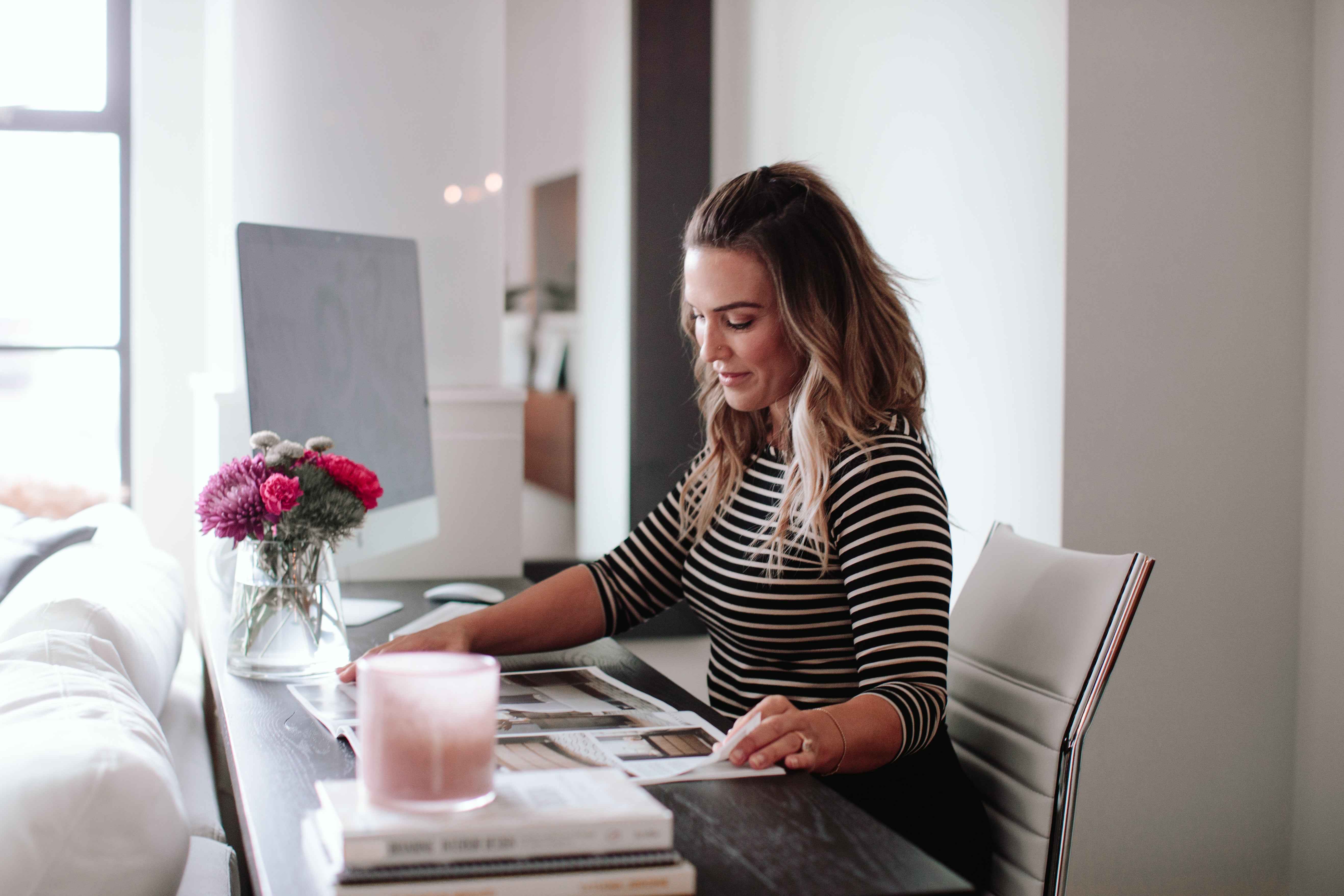 Woman typing on a desktop computer at home. 