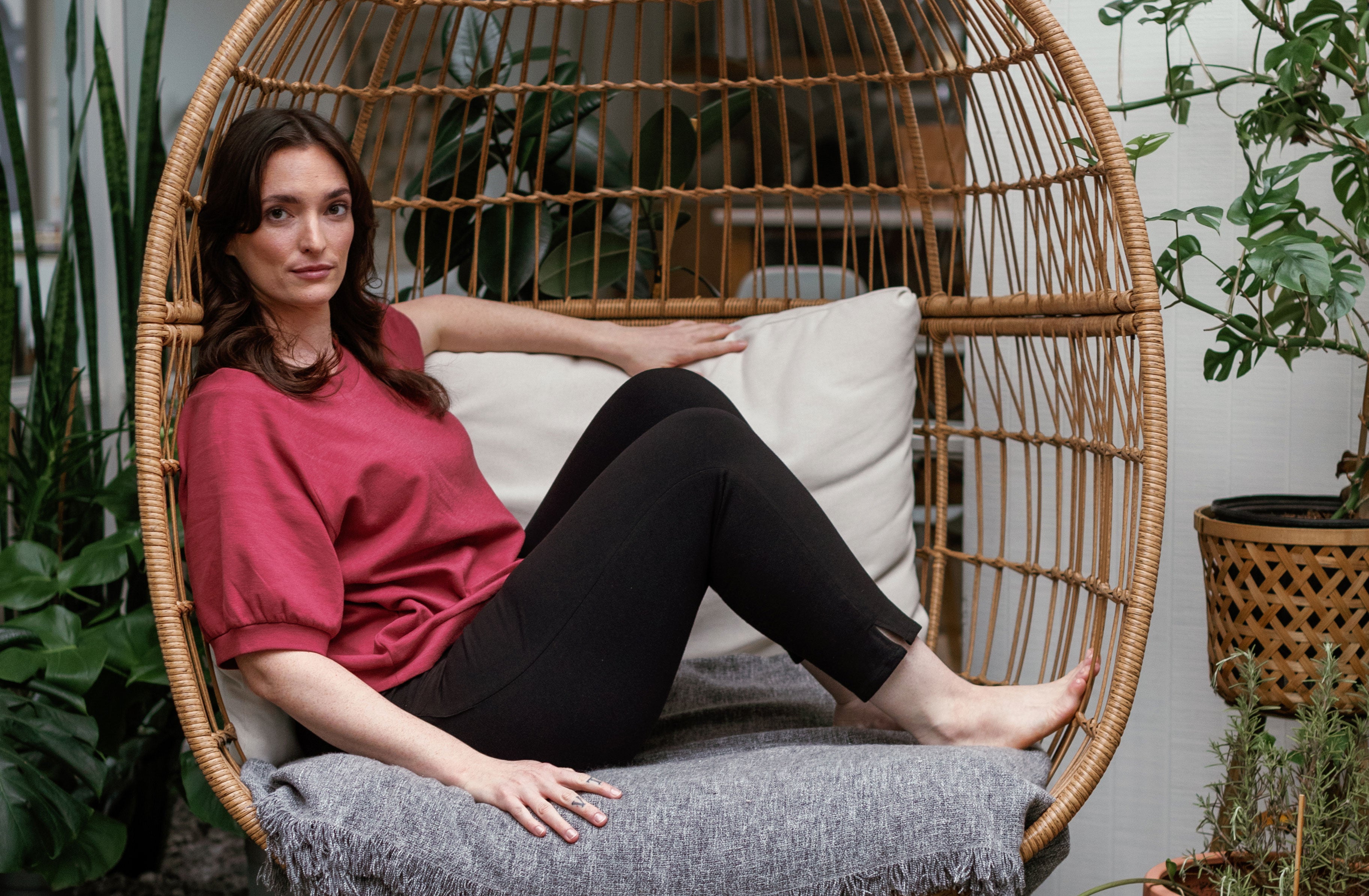 Women lounging in an egg chair in cozy YALA basics.