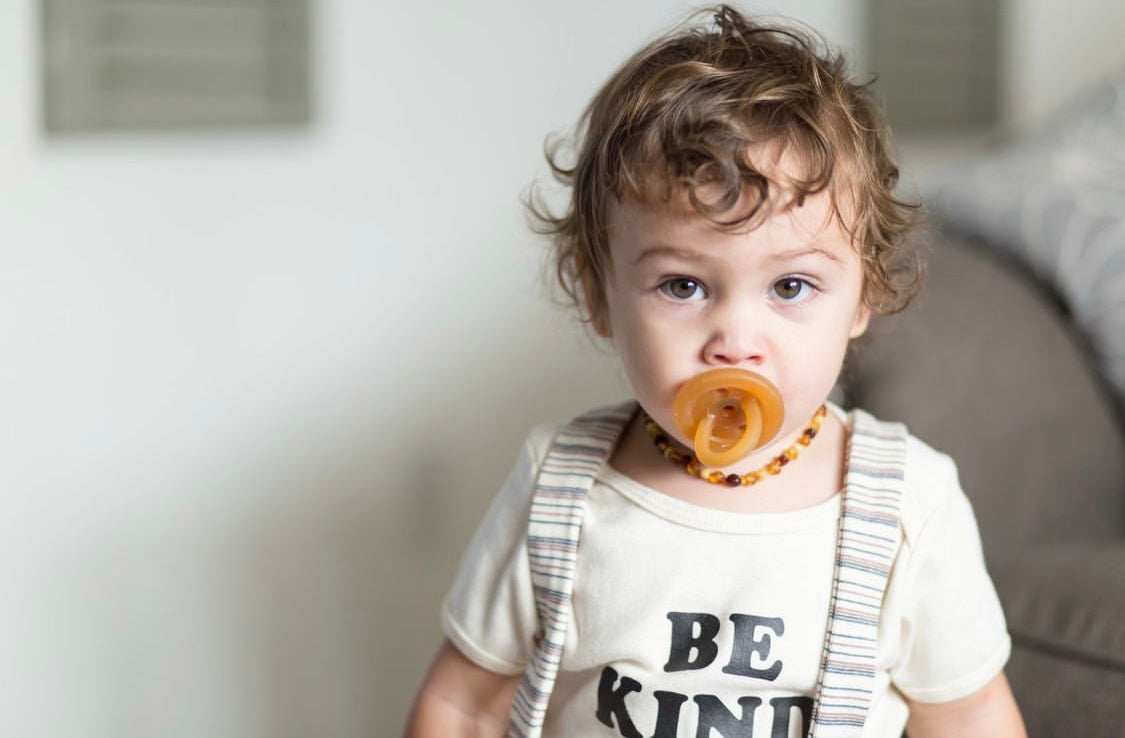 Toddler with a natural rubber pacifier