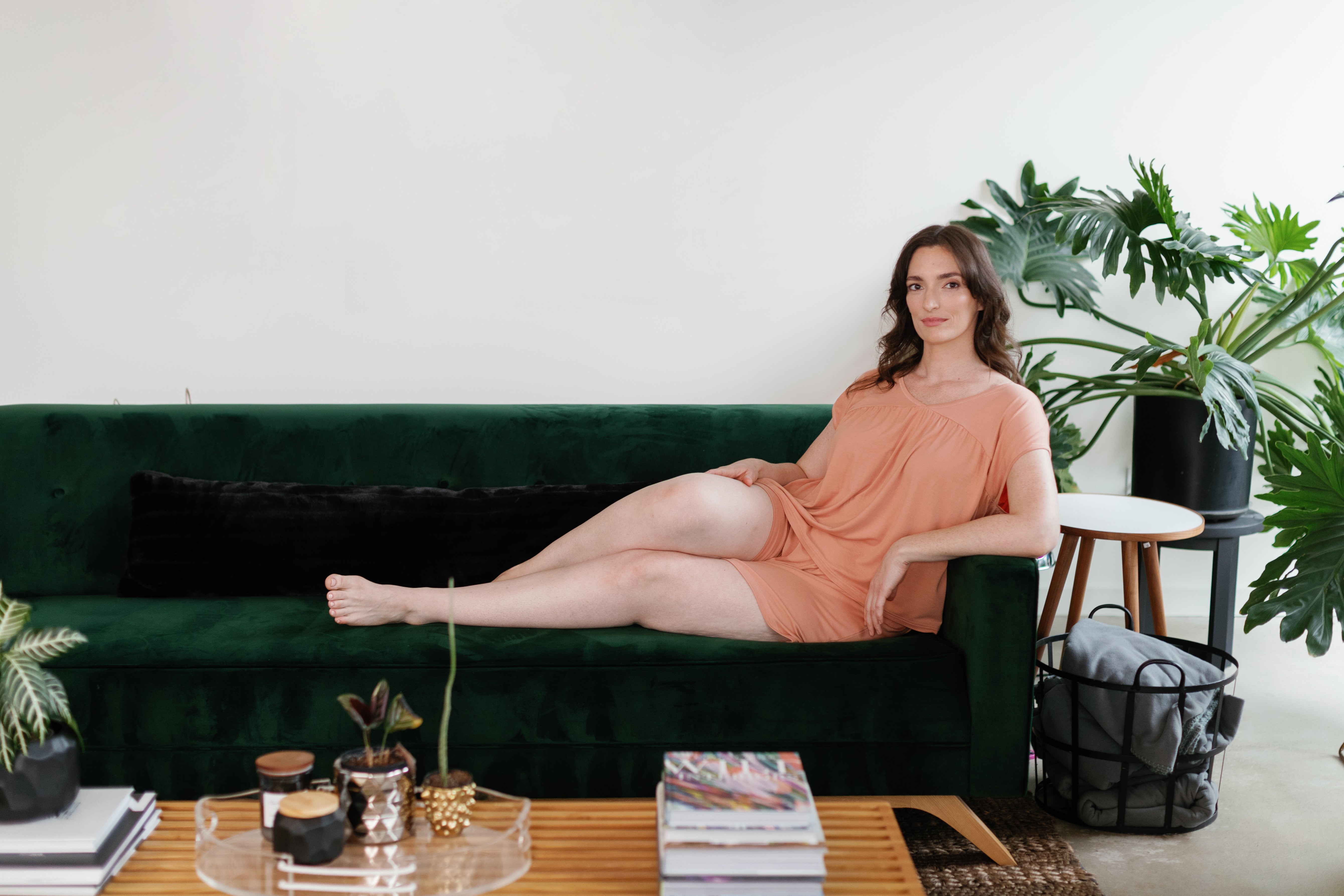 Women lounging on a green couch in an apricot colored Naomi PJ Set.