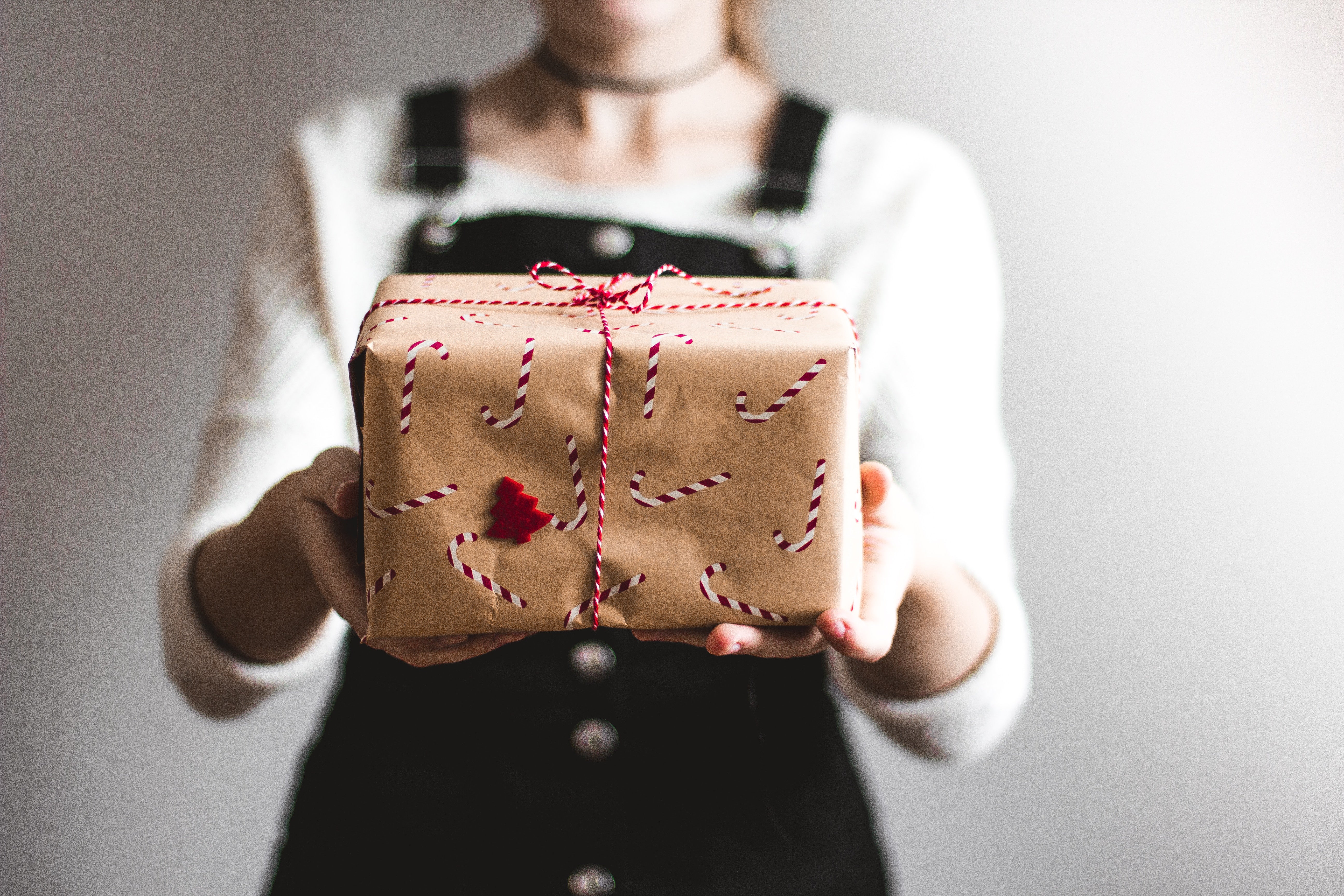 Young woman holding a paper wrapped package.