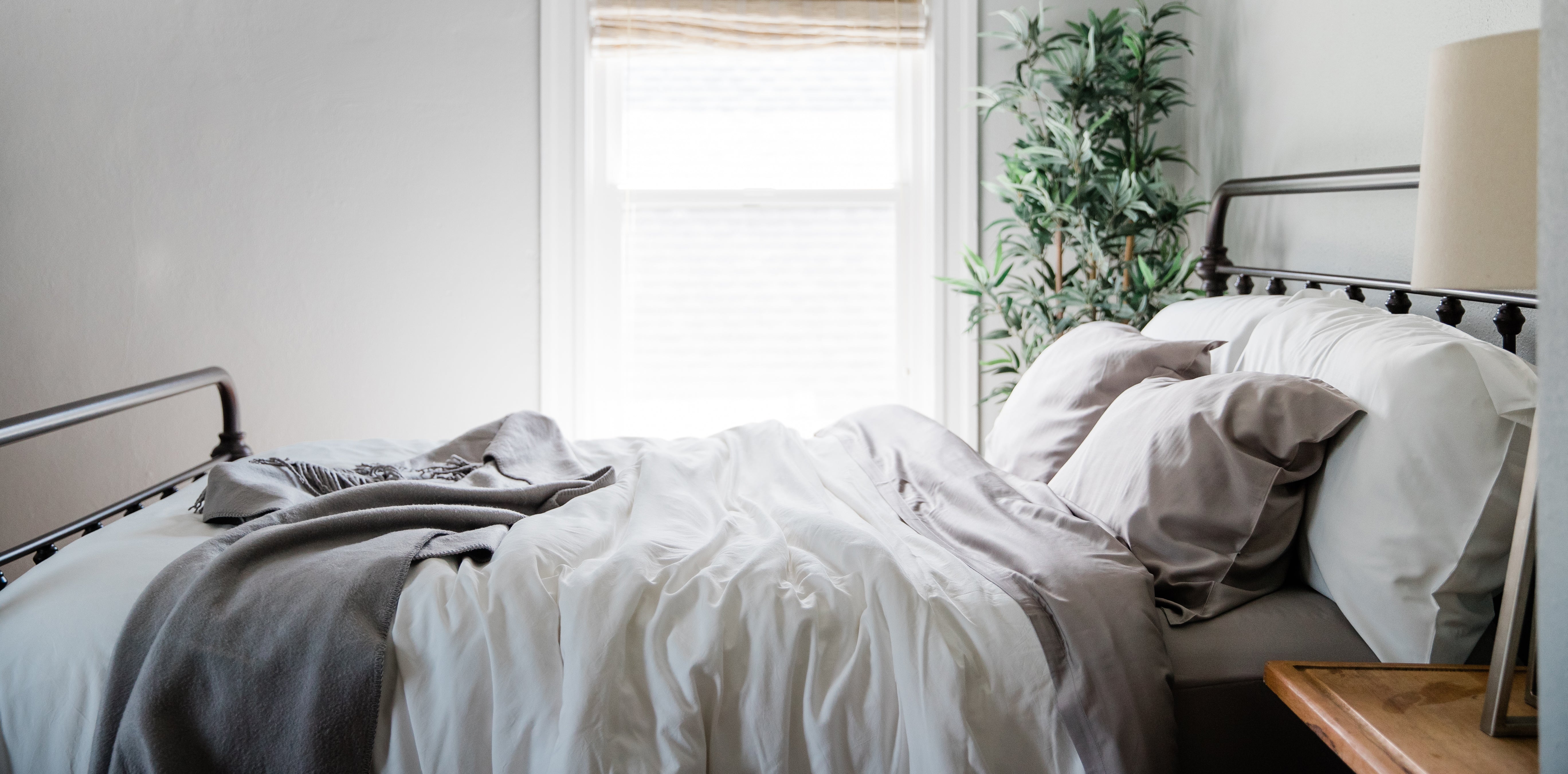 A cozy bed with Natural and Driftwood Colored YALA Bamboo Bedding