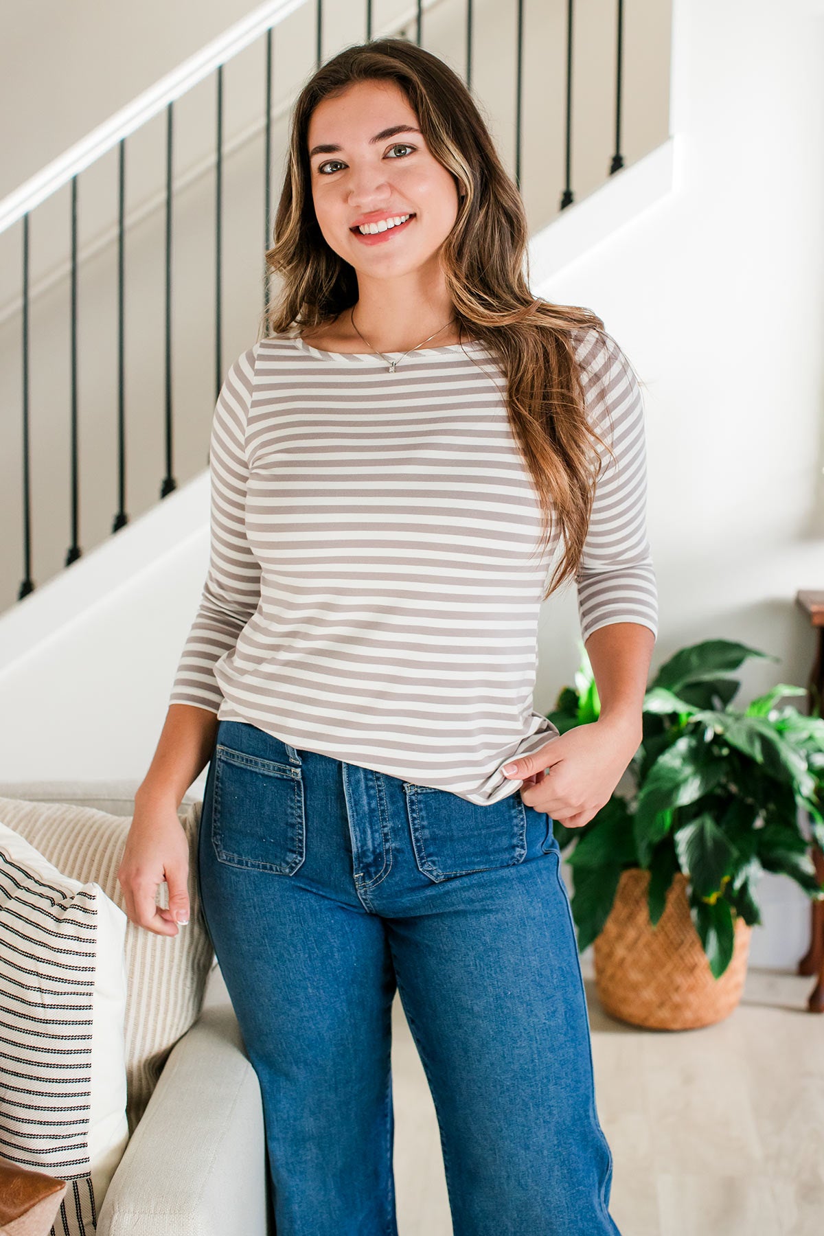 A woman standing with her hips tilted and one hand in her pockets, wearing Yala Kai Boatneck 3/4 Sleeve Relaxed Fit Bamboo Tee Shirt in Ash Natural Stripe