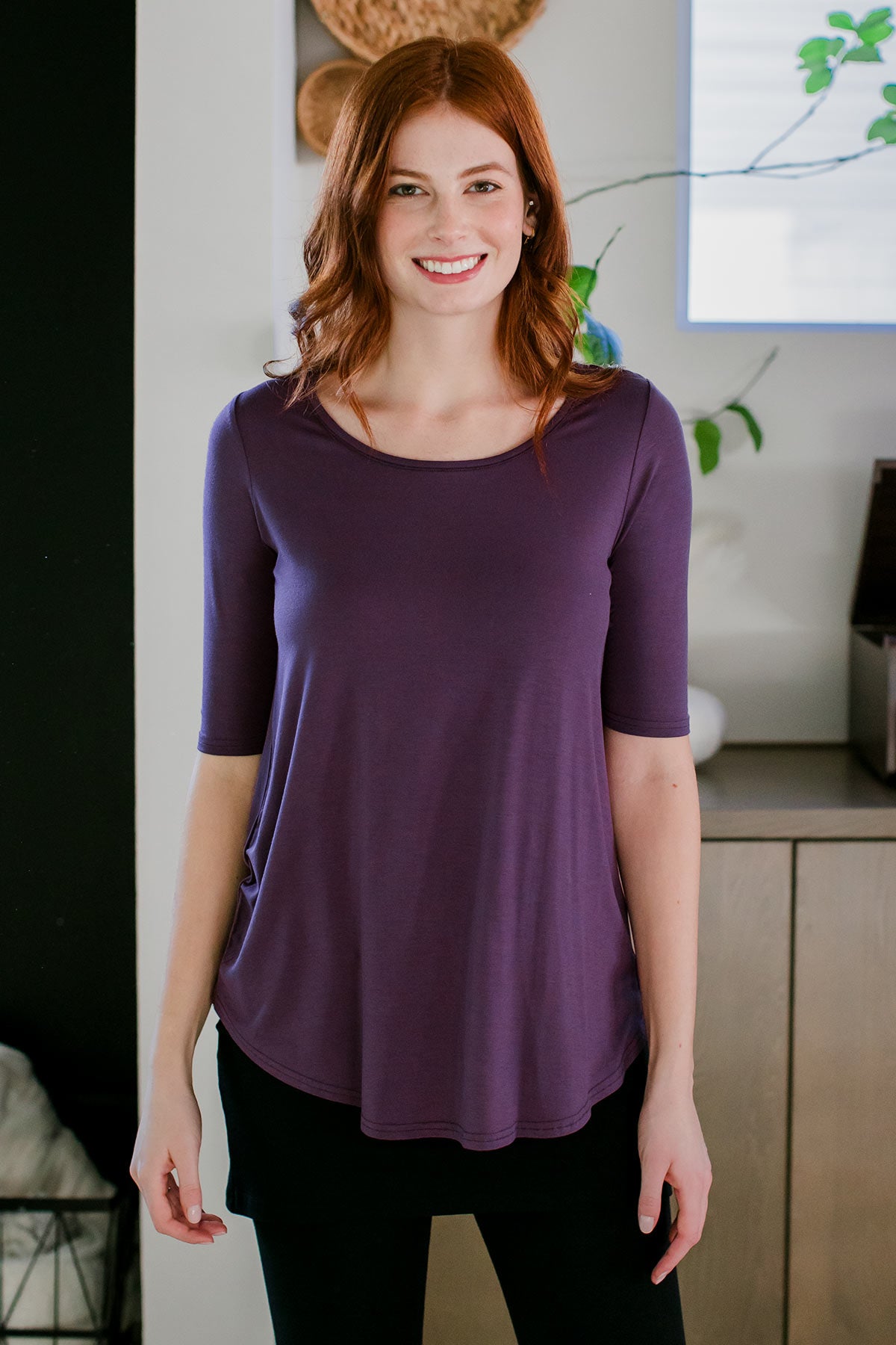 A woman standing with her hips tilted and both hands at her sides, wearing Yala Sandy Relaxed Fit Scoop Neck Short Sleeve Bamboo Top in Aster