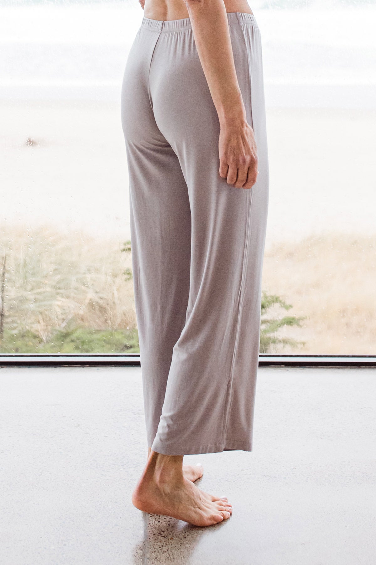 Close shot of a woman's hips and legs from behind, wearing Yala Haley Crossover Front Three Quarter Sleeve Bamboo Pajama Set Bottoms in Ash