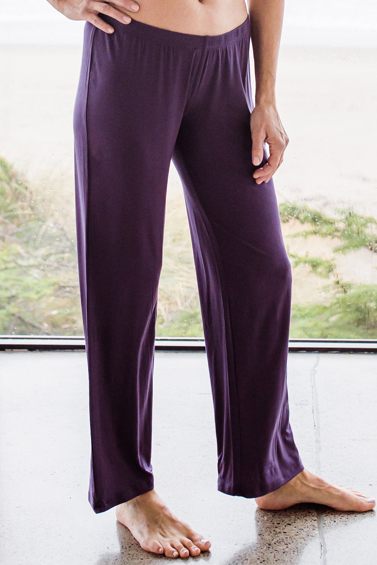Close shot of a woman's hips and legs with one hand on her hip, wearing Yala Norah Long Sleeve Bamboo Pajama Set Bottoms in Aster