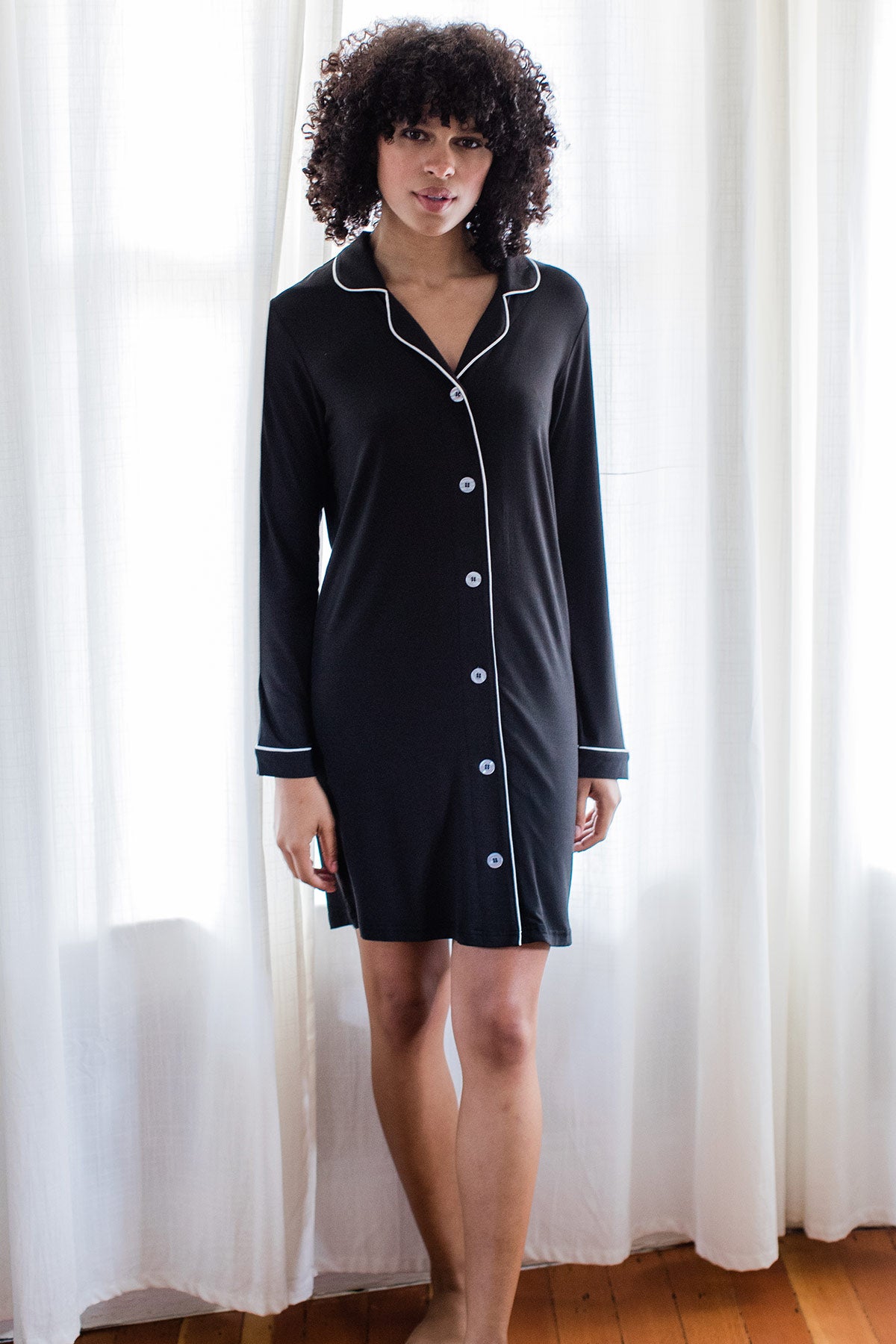 A woman standing with one foot forward, wearing Yala Amber Classic Button Front Bamboo Nightshirt in Black