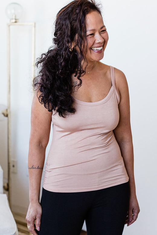 W omans standing and smiling while looking off to the side, wearing Yala Belle Cami Camisole Bamboo Tank Top in Bisque