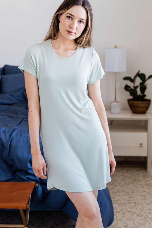 A woman standing with one leg crossed in front of the other, wearing Yala Betsy Short Sleeve Fitted Bamboo Nightshirt in Honeydew