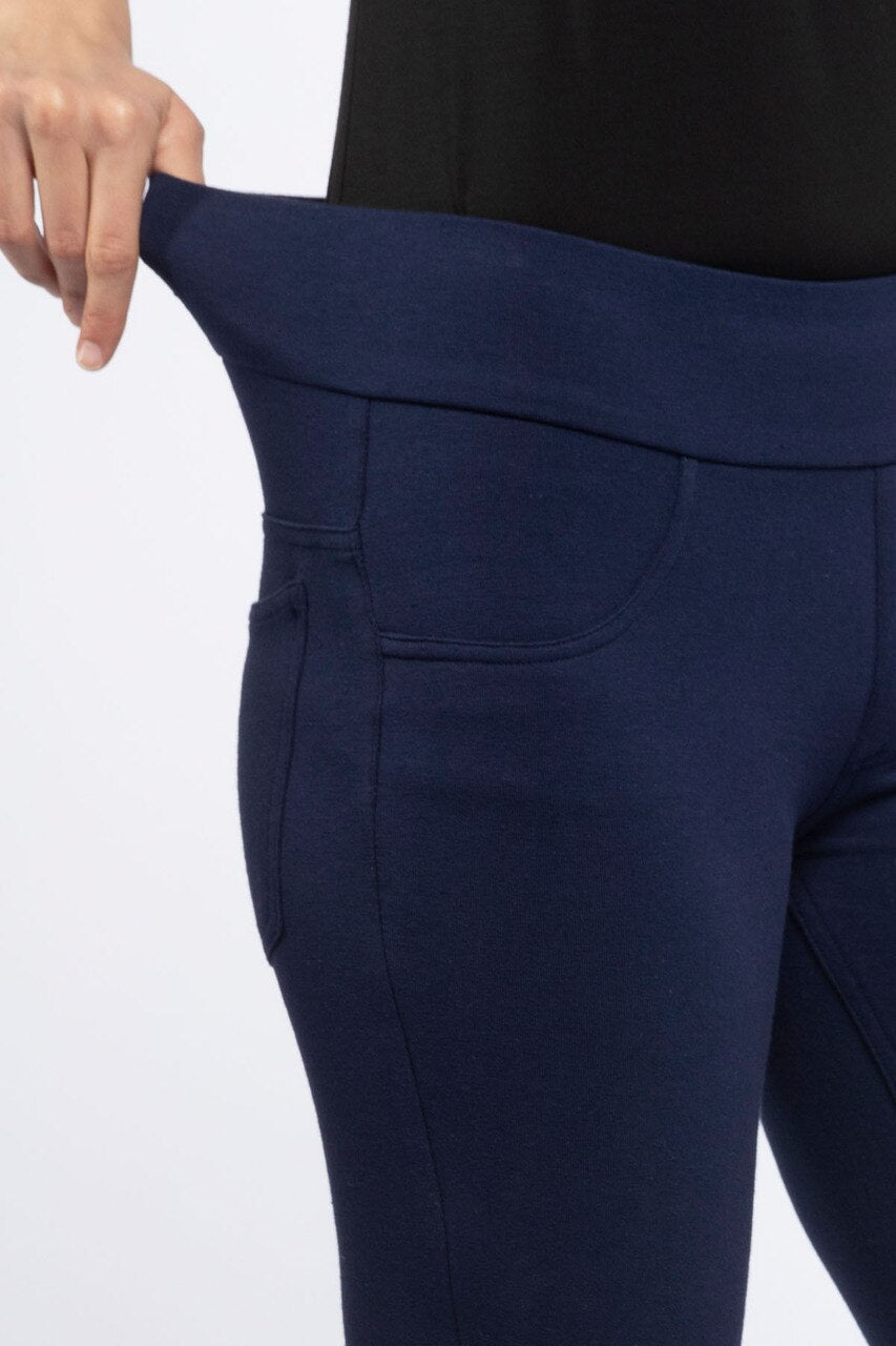 Close shot of a woman's hips with one hand stretching her waistband, wearing Yala Blake Tailored Bamboo and Organic Cotton Skinny Pants in Navy