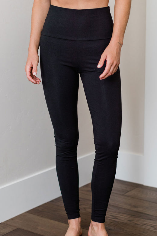 Close shot of a woman's legs, wearing Yala Breilyn Ultra-Stretch High-Waisted Bamboo and Organic Cotton Leggings in Black