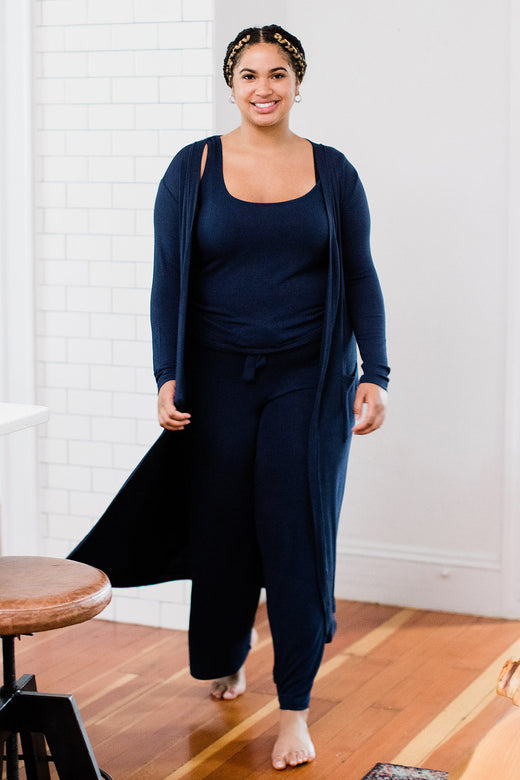 A woman standing and smiling, wearing Yala Brooke Cardigan Duster Bamboo Sweater in Navy