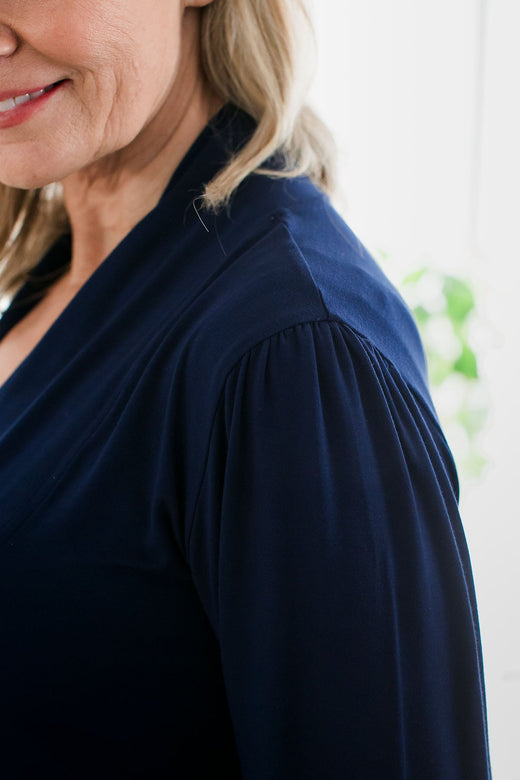 A close shot of a woman's shoulder from the side, wearing Yala Everly Puffed Sleeve Bamboo Wrap in Navy