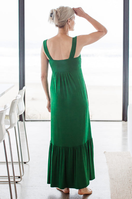 Woman standing with her back turned, one hand raised to her hairline, wearing Yala Cleo Babydoll Bamboo Maxi Dress in Emerald