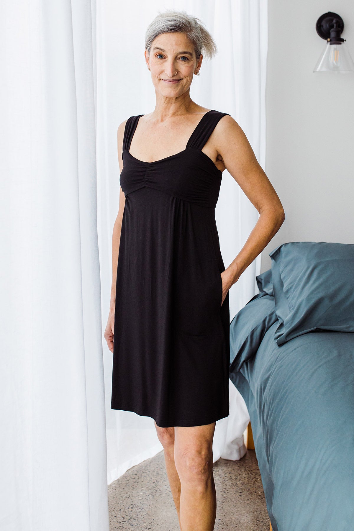 Woman standing with a hand in her pocket, wearing Yala Cleo Babydoll Bamboo Nightgown in Black