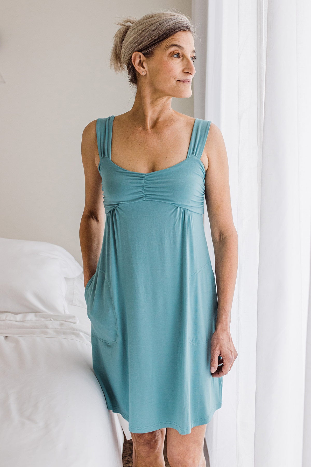 Woman standing and looking ot the side, wearing Yala Cleo Babydoll Bamboo Nightgown in Nile