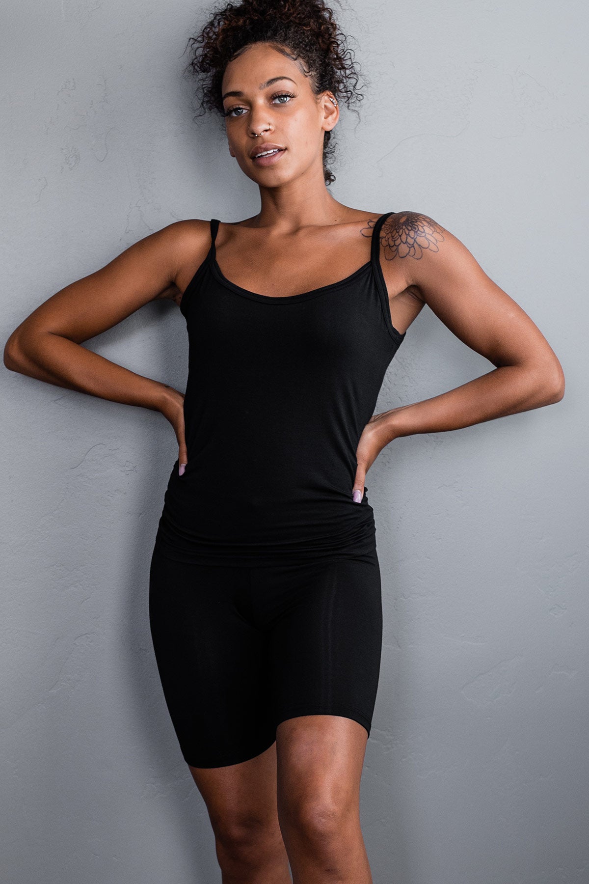 A woman standing with both hands on her hips, wearing Yala Cora Camisole Bamboo Slip in Black