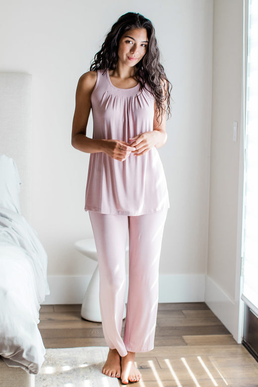 A woman standing and smiling with both hands held in front of her, wearing Yala Delia Gathered Tank Bamboo Pajama Set in Lotus Pink