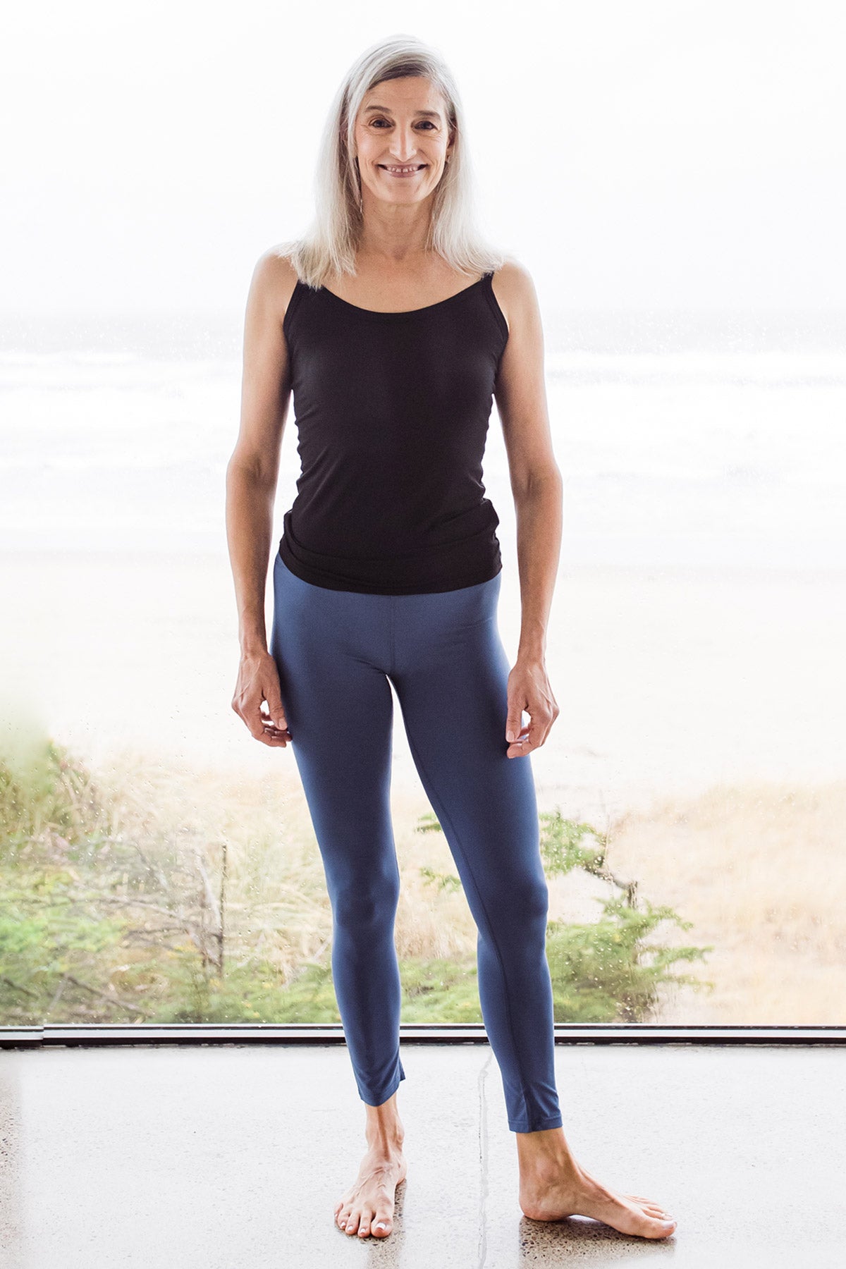Woman standing and smiling, wearing Yala Grace Buttersoft™ Bamboo Full Length Leggings in Twilight