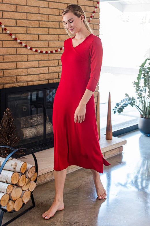 A woman striding in front on a fireplace, wearing Yala Haley Crossover Front Three Quarter Sleeve Bamboo Nightgown in Crimson