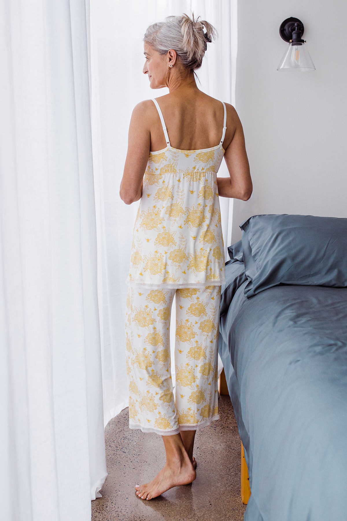 Woman standing with her back turned, wearing Yala Iris Lace Bamboo Pajama Set in Honeybee