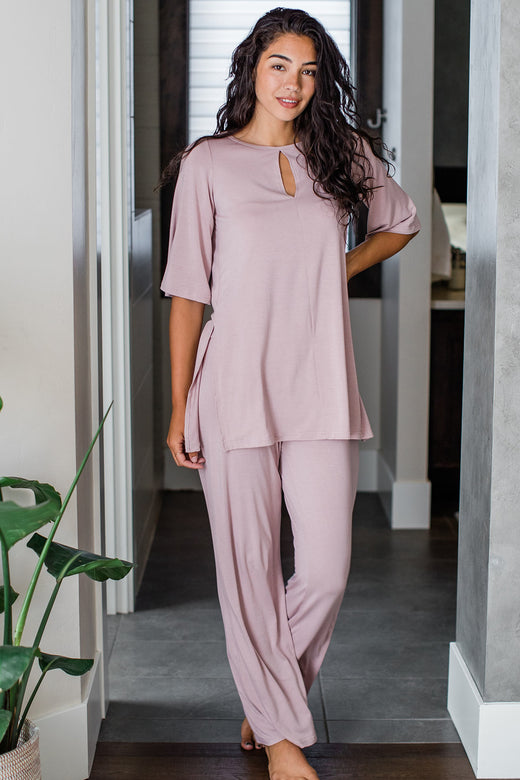 A woman standing with one foot forward and one hand on her hip, wearing Yala Kat Lounge Bamboo Pajama Set in Lotus Pink