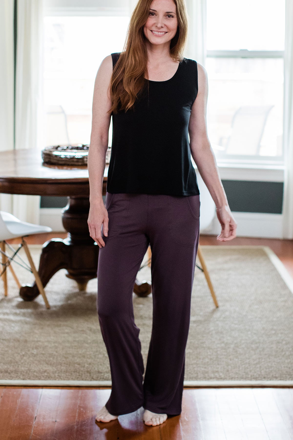 A woman standing and smiling with one knee bent to the side, wearing Yala Kayla Wide Leg Foldover Waist Bamboo Pants in Mink