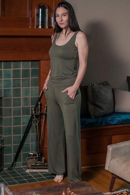 A woman standing facing slightly to the side, wearing Yala Kayla Wide Leg Foldover Waist Bamboo Pants in Moss