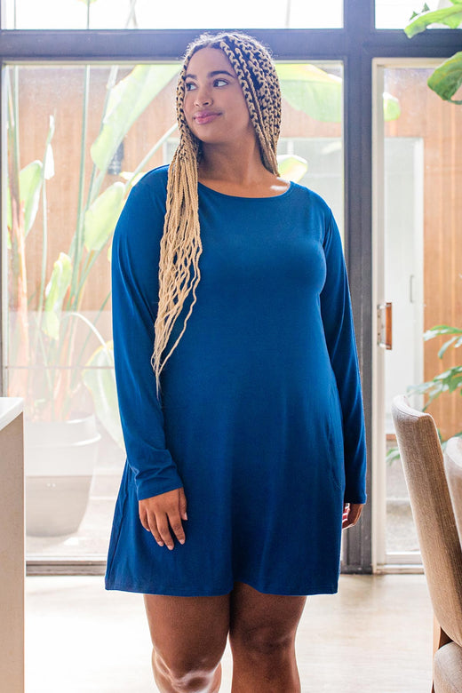 A woman standing and looking upward and to the side, wearing Yala Mia A-Line Bamboo Dress in Lapis