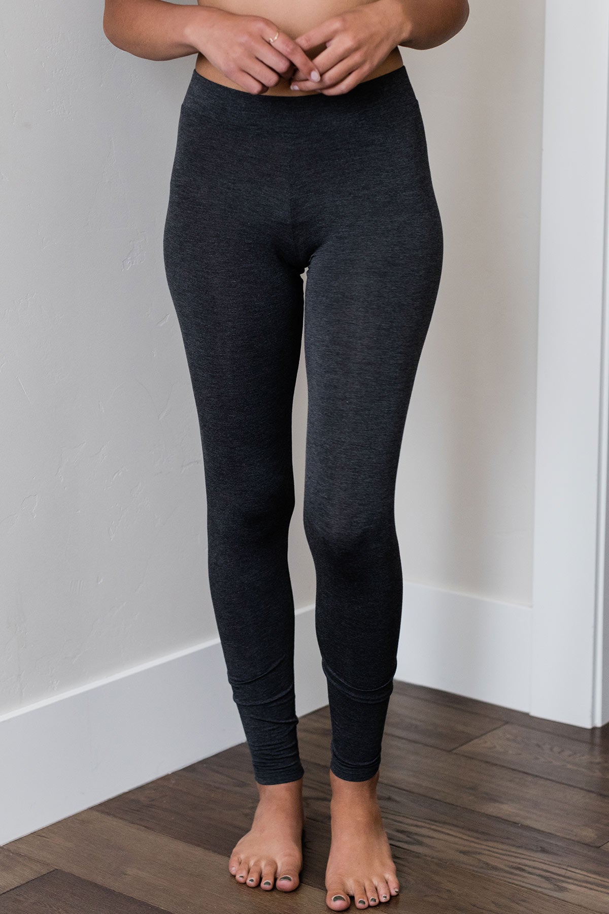 Close shot of a woman's hips and legs, wearing Yala Nellie Full Coverage Bamboo Leggings in Charcoal Melange