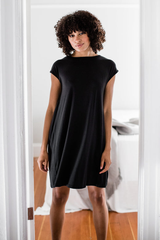 A woman standing in a doorway with both hands at her sides, wearing Yala Opal Swing Bamboo Nightshirt in Black