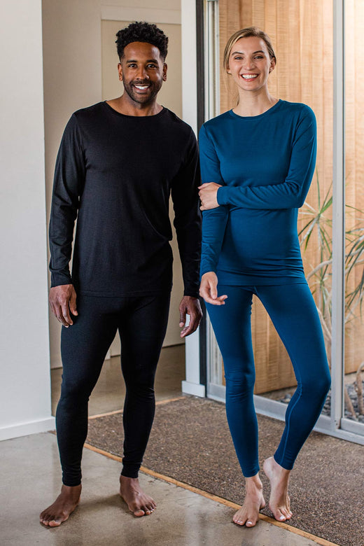 A woman and man stand together smiling, both wearing Yala Superfine Merino Wool Leggings in Black and Lapis
