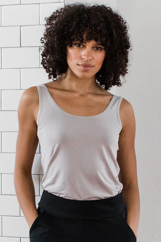A womand standing with both hands in her pockets, wearing Yala Zia Layering Bamboo Tank Top in Ash