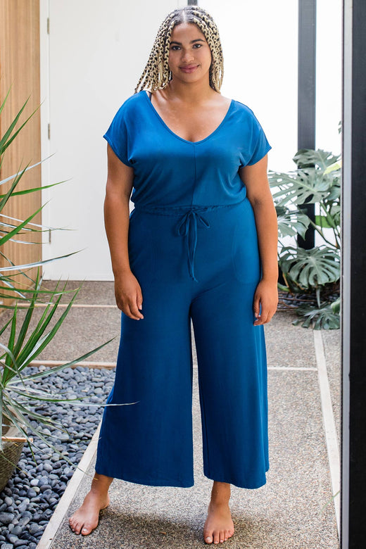 A womand standing with both hands at her sides, wearing Yala Kiova V-Neck Bamboo Jumpsuit in Lapis