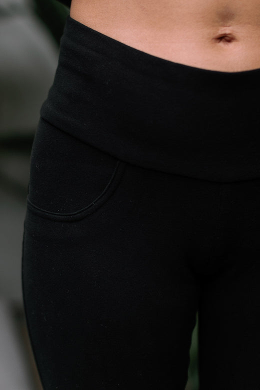 Close shot of a woman's hips, wearing Yala Abby Mid-Waist Cropped Bamboo and Organic Cotton Pencil Pants in Black