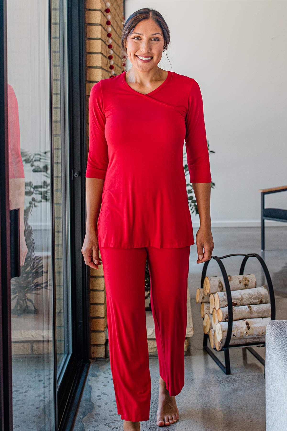 A woman standing and smiling, wearing Yala Haley Crossover Front Three Quarter Sleeve Bamboo Nightgown in Crimson