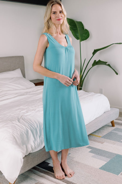 A woman standing with her hands held together in front of her stomach, wearing Yala Molly Sleeveless Bamboo Nightgown in Nile